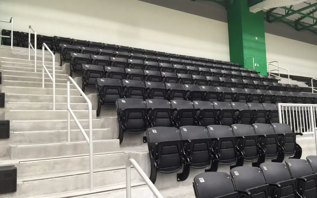 Black, indoor arena seats are arranged as stadium seating.