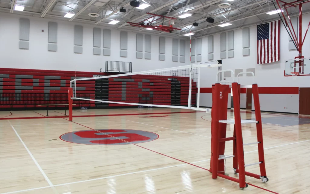 Indoor volleyball system and net installed in gym.