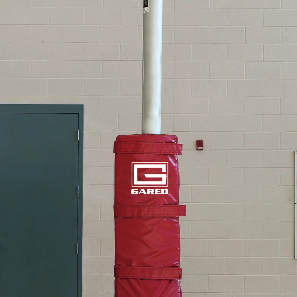 Volleyball pole padding installed in gym.